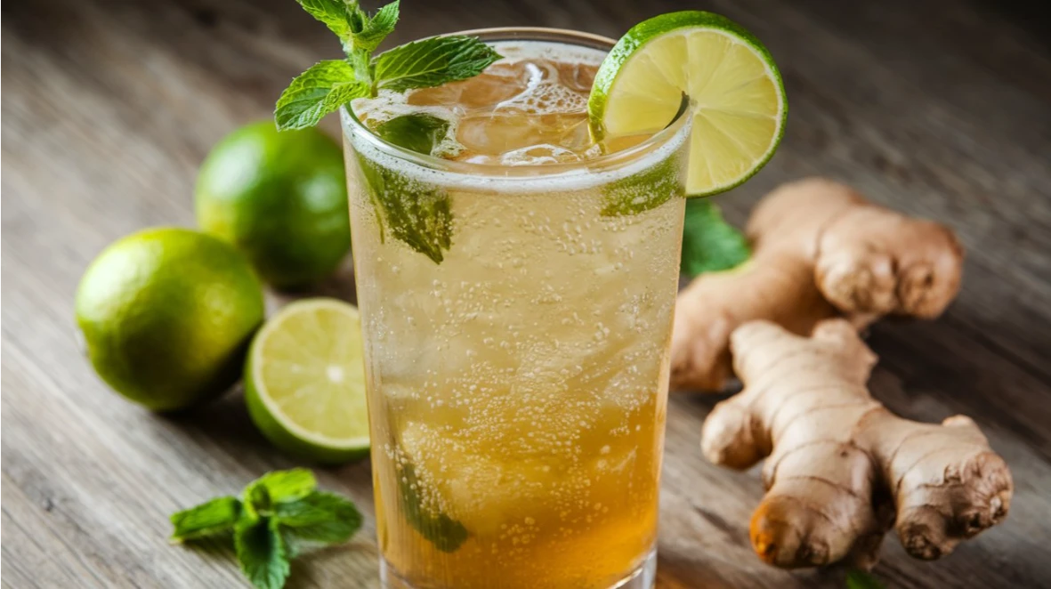 A zesty Ginger Beer Mocktail in a tall glass, garnished with mint and lime, fizzing with refreshing appeal