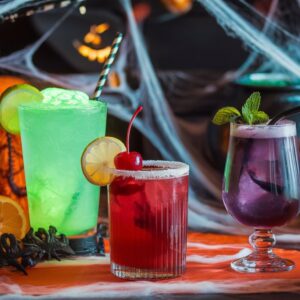 A festive Halloween mocktail bar featuring colorful non-alcoholic drinks and spooky decorations for a haunting good time.