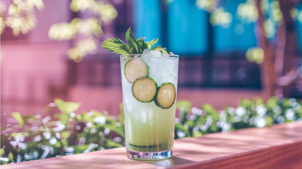 A refreshing cucumber mocktail in a tall glass, garnished with cucumber slices and mint, perfect for spring sipping.