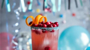  A cranberry mocktail in a modern, sleek design that includes subtle party decorations like confetti and balloons to convey a festive vibe. 