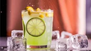 A softly clouded yellow-green citrus mocktail with fresh lime wheels pressed against the glass, floating citrus segments, and gentle carbonation, served over ice with natural glass condensation