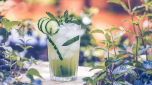 A cool and crisp cucumber mint mocktail with cucumber ribbons and fresh mint leaves, served in a clear glass with ice cubes