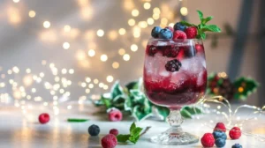 A Festive Berry Fizz in a stemmed glass, garnished with frozen berries and mint, surrounded by holiday accents.