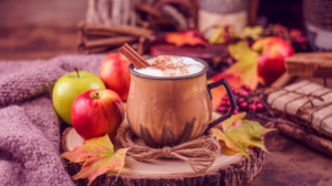 Warm apple cider mocktail in a rustic mug with autumn-inspired decorations