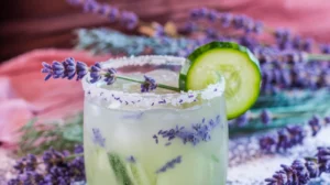 a Winter Lavender Cucumber Cooler mocktail in a frosted glass, showcasing a soft, light green drink infused with cucumber water and a subtle lavender tint.