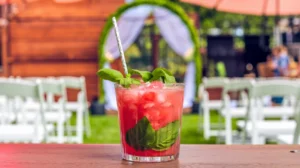 A bright pink watermelon basil mocktail with fresh basil leaves, creating a refreshing and visually stunning wedding mocktail